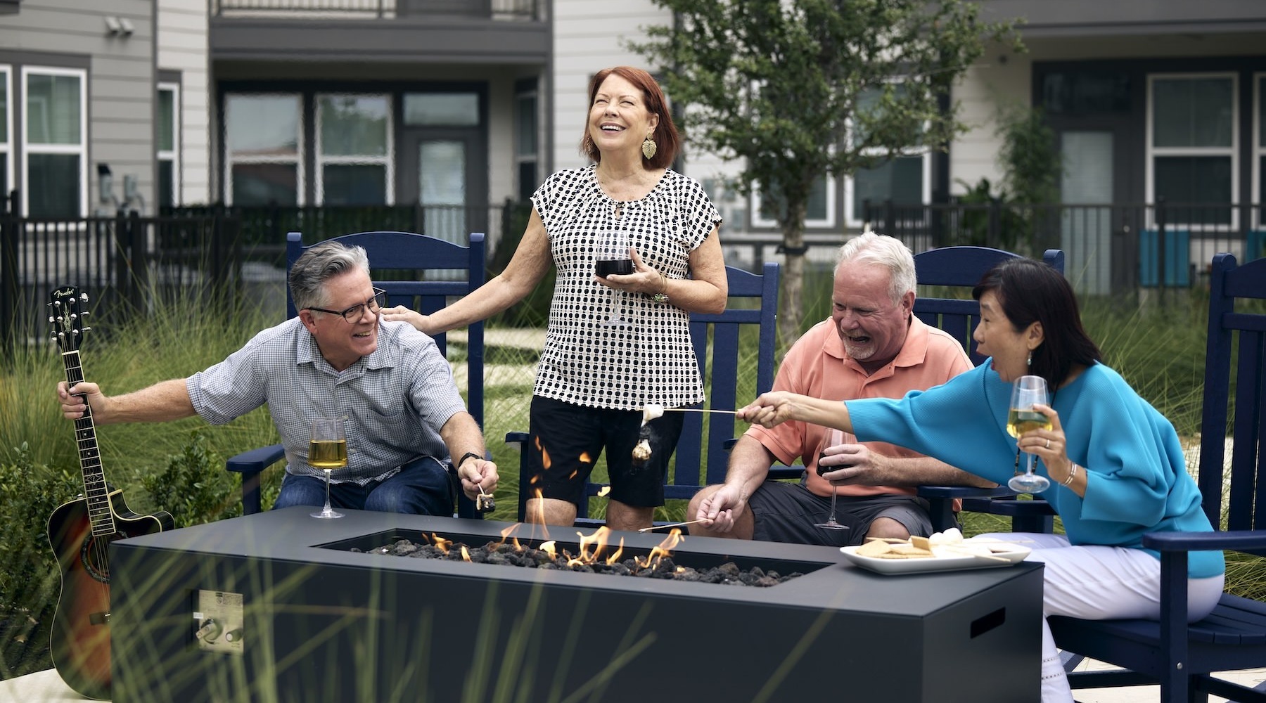 a group of people laughing around a fire